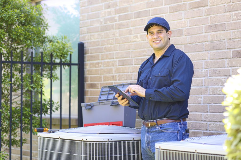 air conditioning technician performing maintenance on ac unit