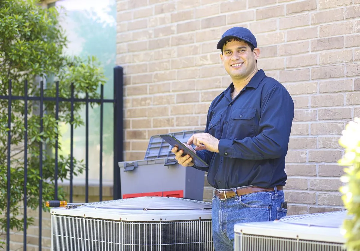 air conditioning technician performing maintenance on ac unit