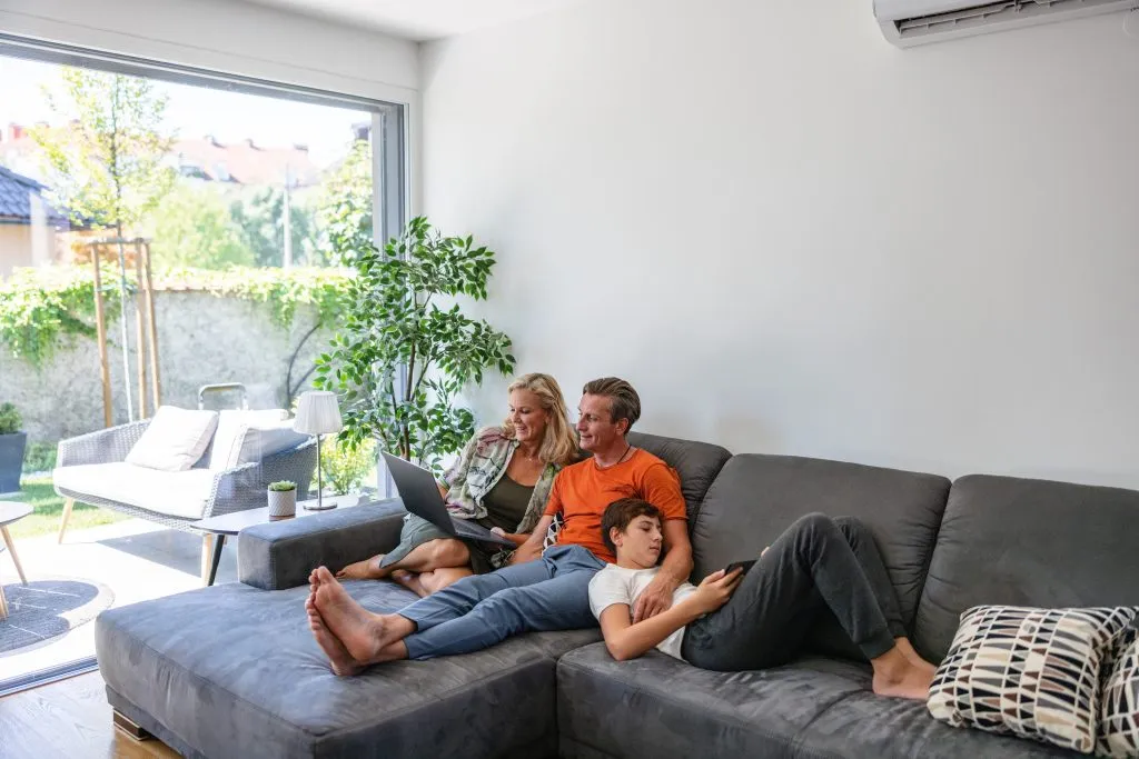 family relaxing in cool temperatures on their couch