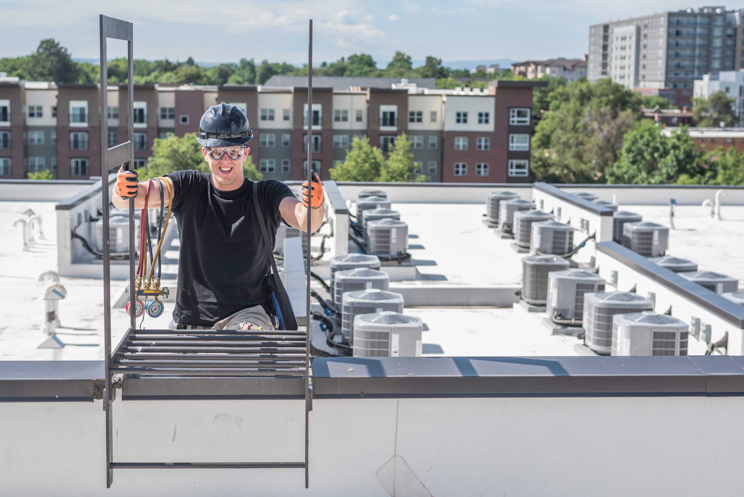 man climbs onto roof to service commercial hvac unit