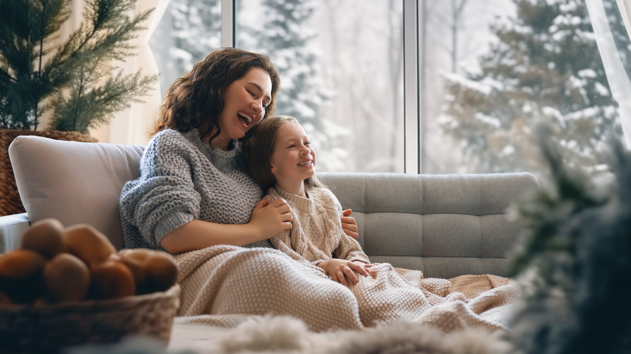 Mother and daughter enjoying winter nature in the window