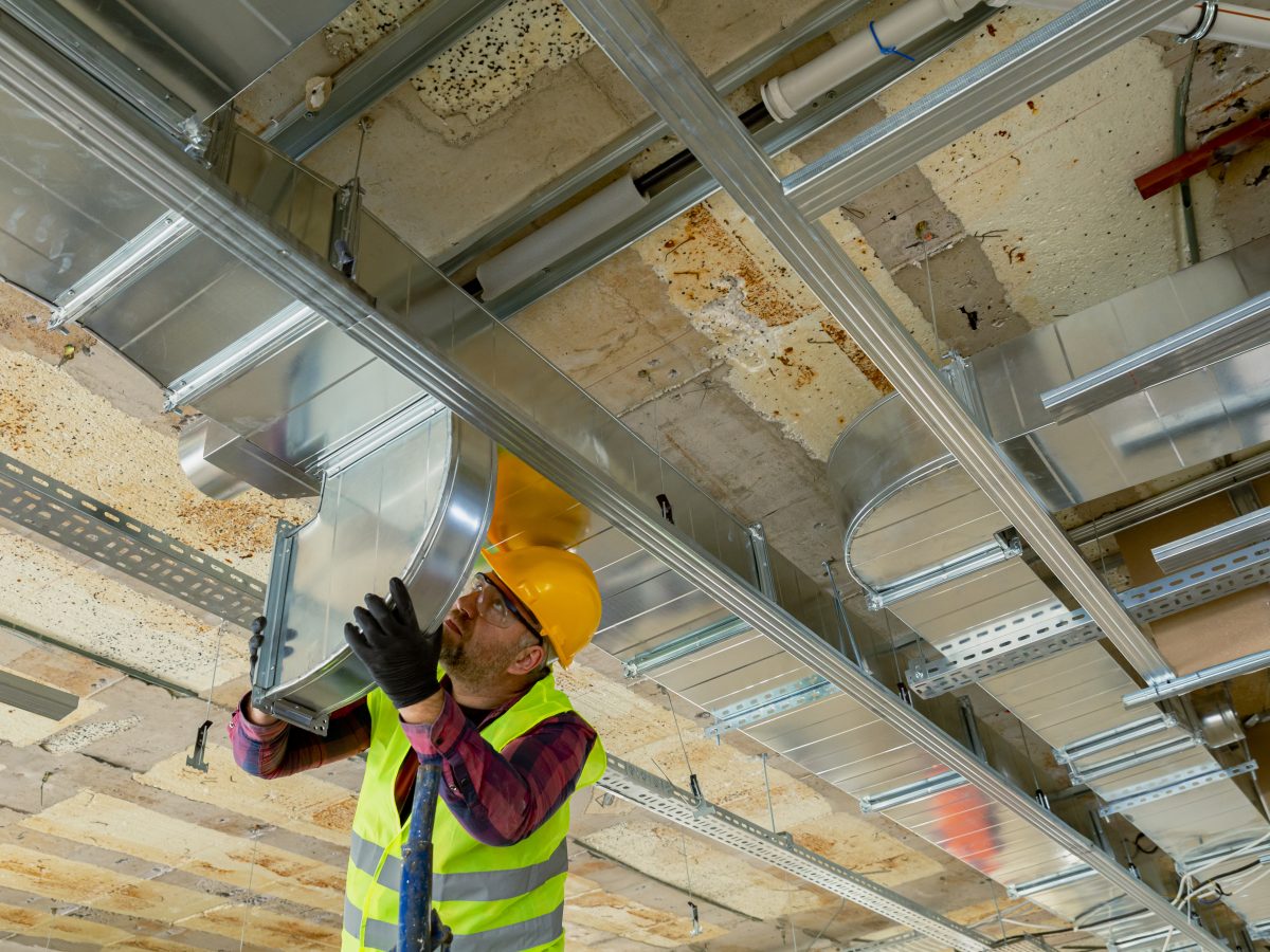 HVAC tech installing air conditioner ductwork