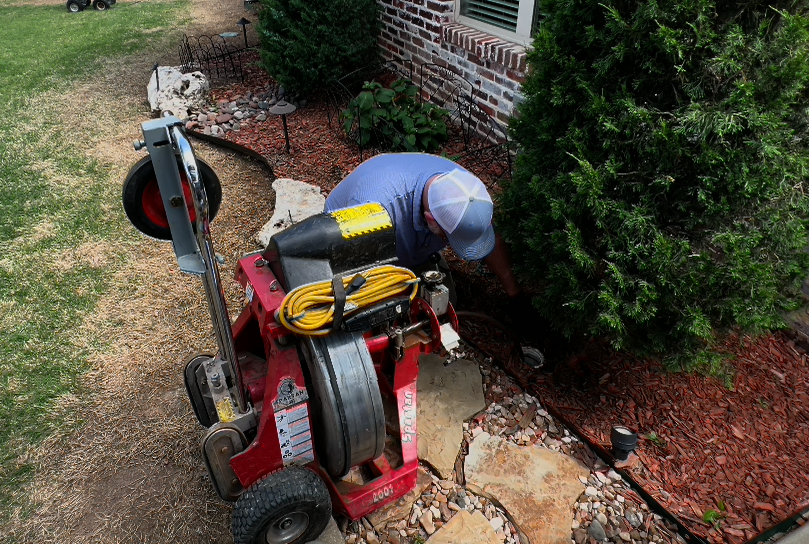 technician performs a main sewer drain cleanout